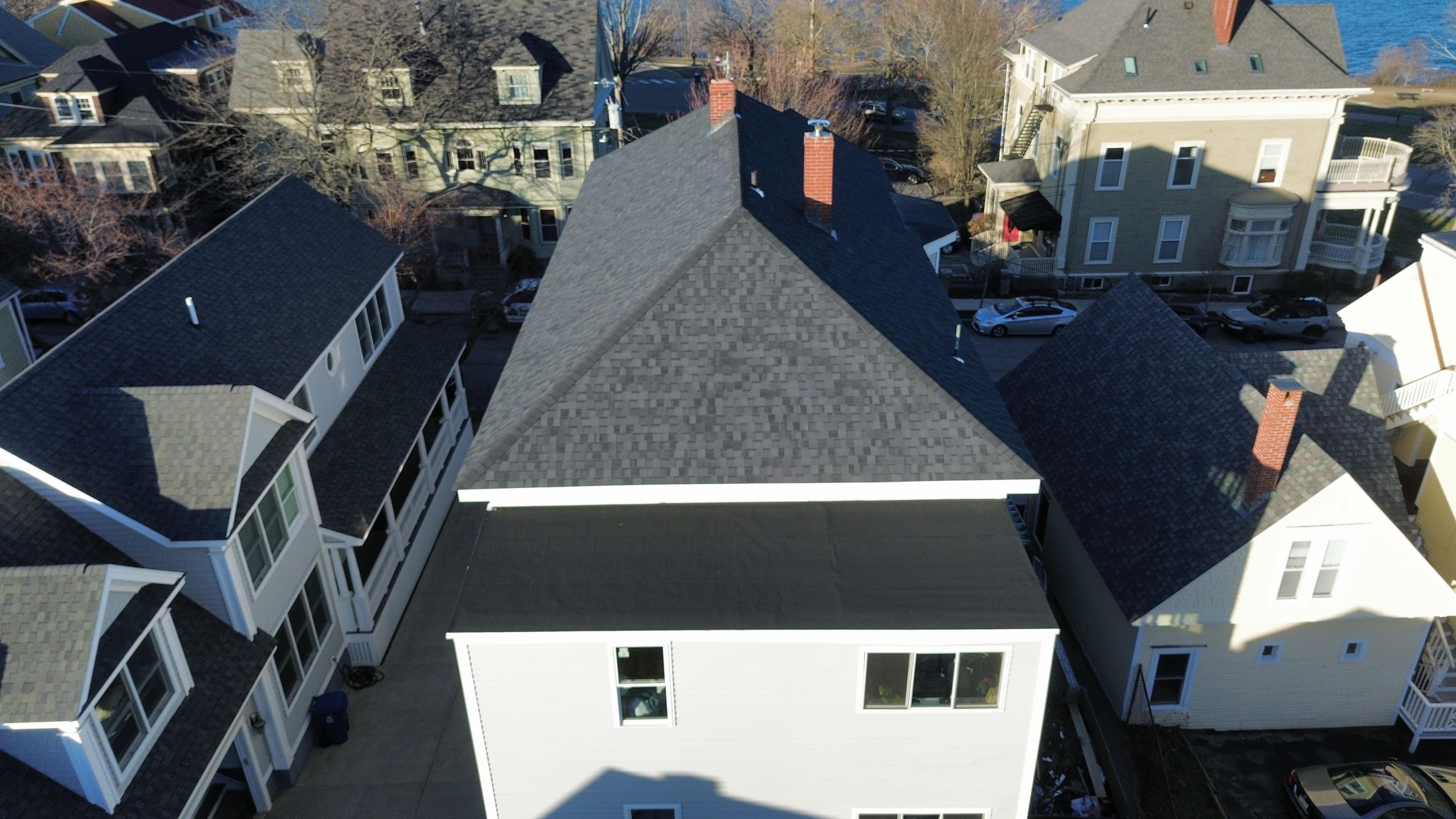 New rolled roofing on a low-slope section of a house, seen from a drone